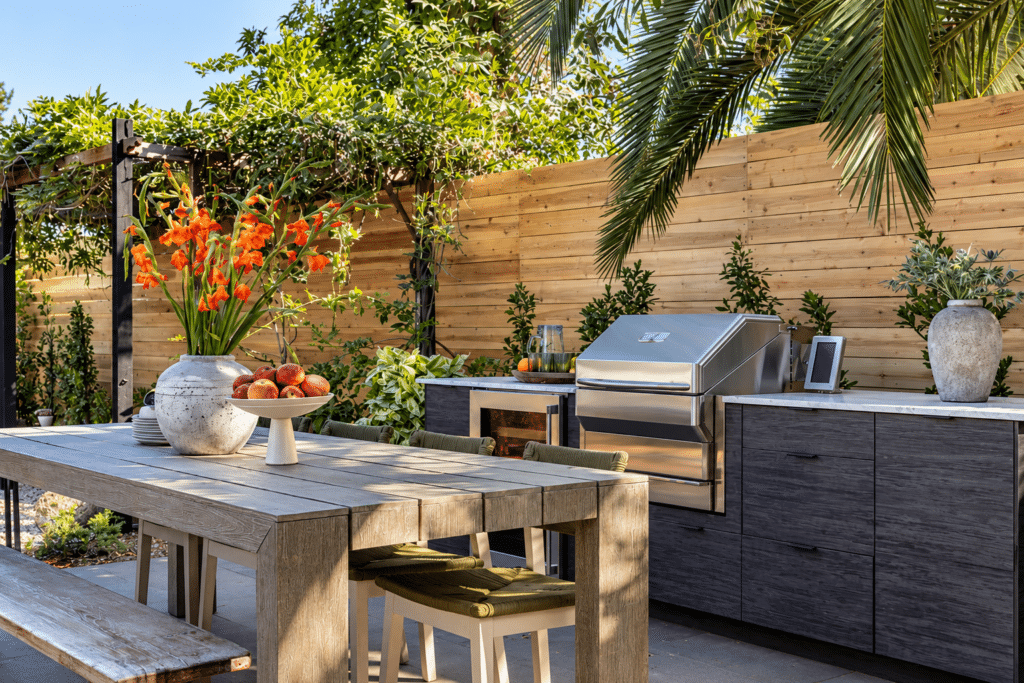 Outdoor kitchen featuring NatureKast weatherproof cabinetry, built-in grill and stone countertops. 